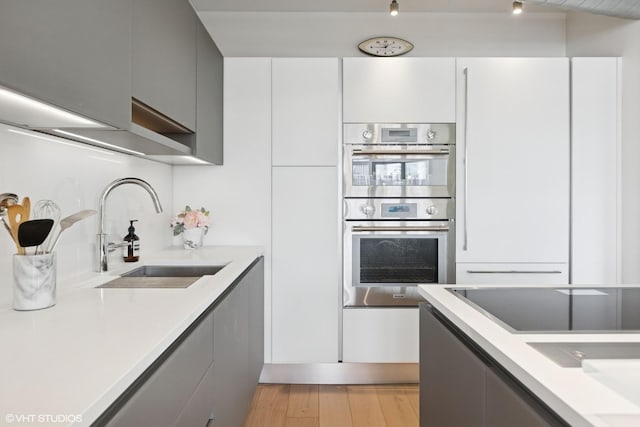 1200 W Monroe St Unit 808, Chicago, IL 60607 - kitchen featuring a sink, double oven, light countertops, and light wood-style floors
