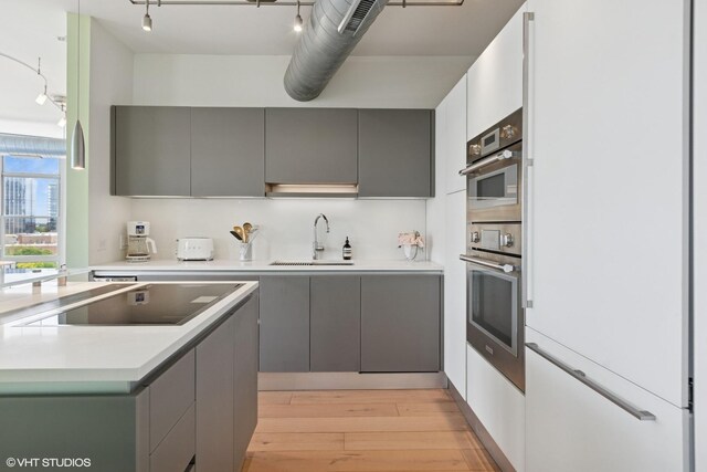 1200 W Monroe St Unit 808, Chicago, IL 60607 - kitchen with a sink, gray cabinets, black electric cooktop, and light wood-type flooring