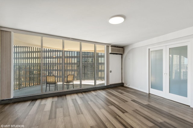 300 N State St Unit 4930, Chicago, IL 60654 - unfurnished room featuring french doors, a wall unit AC, wood finished floors, and floor to ceiling windows