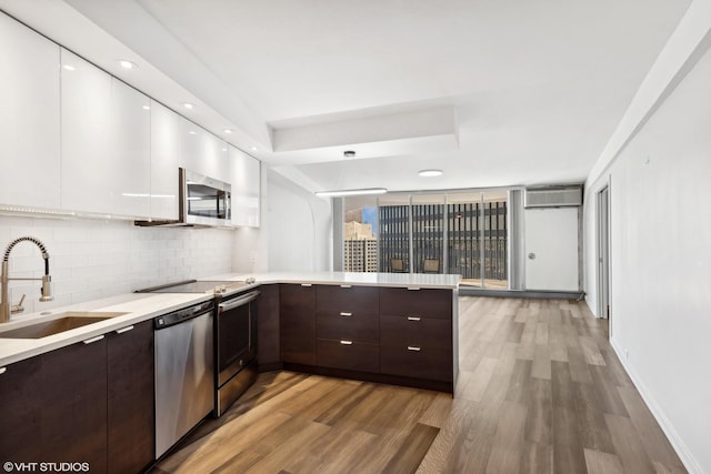 300 N State St Unit 4930, Chicago, IL 60654 - kitchen featuring modern cabinets, a sink, stainless steel appliances, white cabinetry, and dark brown cabinetry