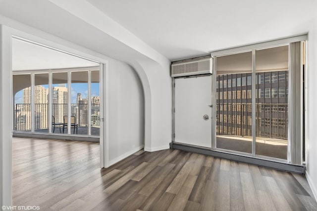 300 N State St Unit 4930, Chicago, IL 60654 - spare room with wood finished floors, a wall mounted AC, baseboards, and a baseboard radiator