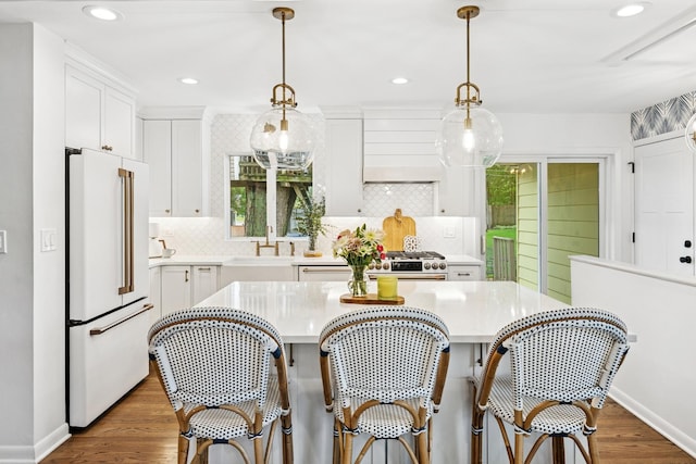114 Washington St, Bloomingdale, IL 60108 - kitchen with freestanding refrigerator, light countertops, wood finished floors, backsplash, and white cabinetry