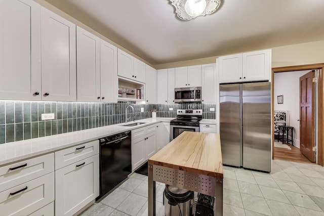 5143 S Greenwood Ave Unit 1, Chicago, IL 60615 - kitchen featuring appliances with stainless steel finishes, light tile patterned flooring, tasteful backsplash, and white cabinets
