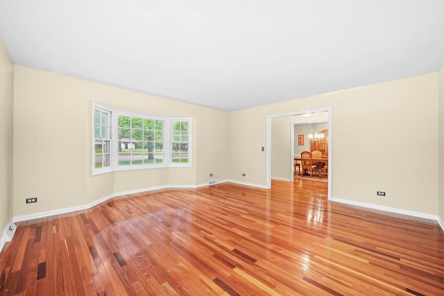 1136 S Naper Blvd, Naperville, IL 60540 - unfurnished room featuring light wood-style floors, a chandelier, and baseboards
