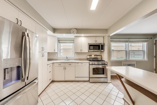 6478 N NW Hwy Unit 1, Chicago, IL 60631 - kitchen with appliances with stainless steel finishes, light countertops, a sink, decorative backsplash, and light tile patterned floors