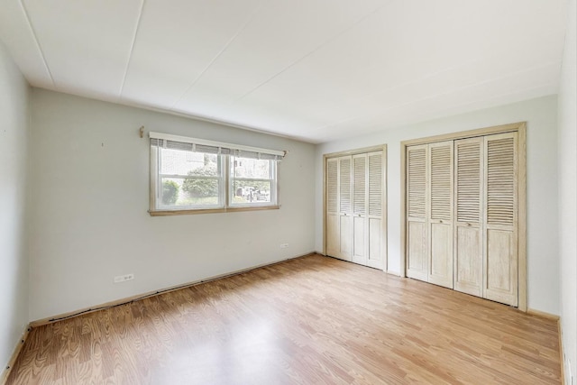 6478 N NW Hwy Unit 1, Chicago, IL 60631 - unfurnished bedroom featuring multiple closets, light wood-style floors, and baseboards