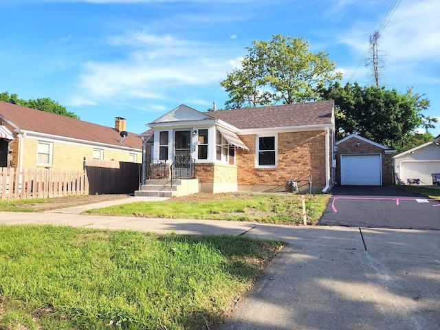 673 Slade Ave, Elgin, IL 60120 - view of front of house with brick siding, driveway, a garage, and an outbuilding
