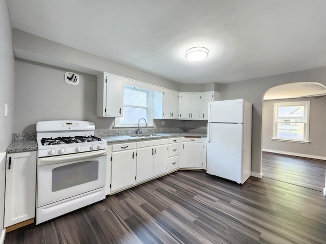 673 Slade Ave, Elgin, IL 60120 - kitchen featuring white appliances, a sink, dark wood-style floors, arched walkways, and white cabinetry