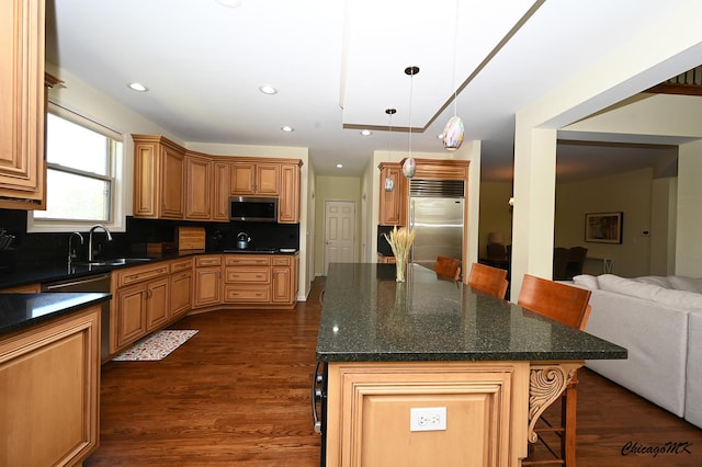 328 Erie Cir, Bloomingdale, IL 60108 - kitchen with appliances with stainless steel finishes, open floor plan, a breakfast bar area, decorative backsplash, and dark wood-style flooring