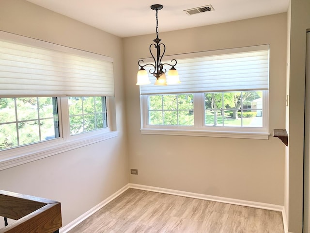 1422 W Orchard Pl Unit B, Arlington Heights, IL 60005 - unfurnished dining area with a chandelier, baseboards, and light wood-type flooring