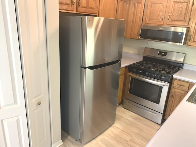 1422 W Orchard Pl Unit B, Arlington Heights, IL 60005 - kitchen with stainless steel appliances, light countertops, light wood-style floors, and brown cabinets