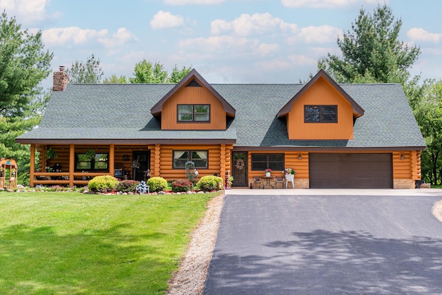 310 N Oak Ln, Dixon, IL 61021 - cabin featuring log exterior, covered porch, a front yard, and a garage