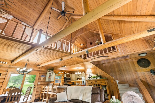310 N Oak Ln, Dixon, IL 61021 - living room featuring a chandelier, wooden ceiling with exposed beams, high vaulted ceiling, wooden walls, and stairs