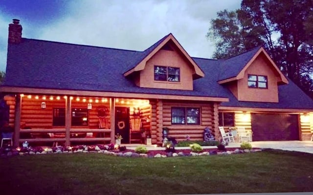 310 N Oak Ln, Dixon, IL 61021 - log cabin featuring log siding, a chimney, concrete driveway, a garage, and a front lawn