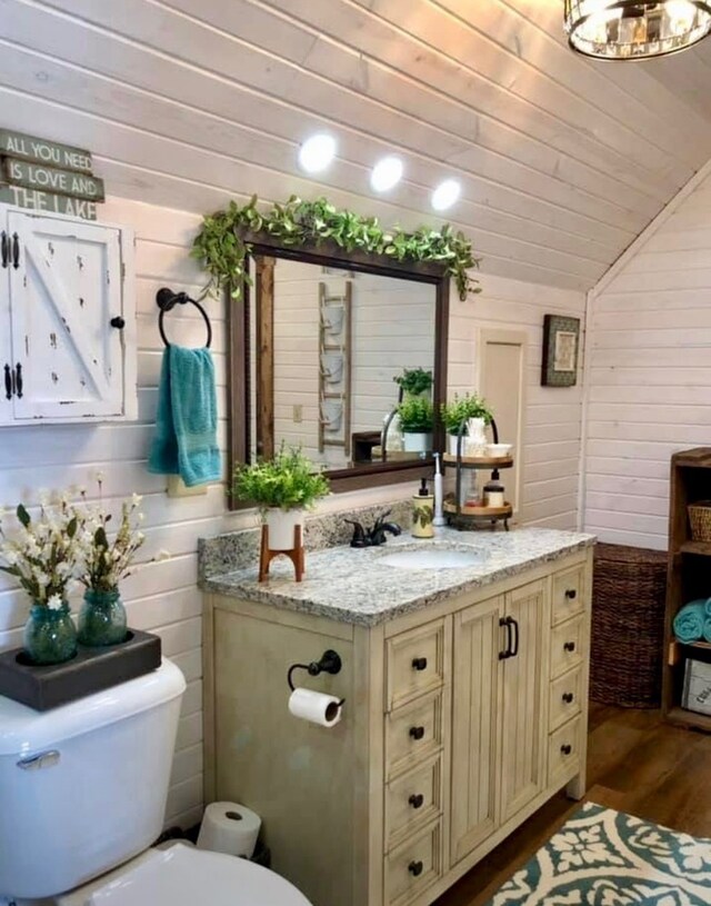 310 N Oak Ln, Dixon, IL 61021 - half bathroom featuring toilet, vanity, wood finished floors, wood ceiling, and wood walls