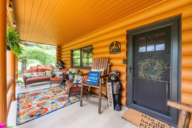 310 N Oak Ln, Dixon, IL 61021 - view of exterior entry with an outdoor hangout area, log exterior, and a porch