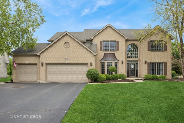 651 Clover Dr, Algonquin, IL 60102 - traditional-style home featuring an attached garage, driveway, a front yard, and roof with shingles
