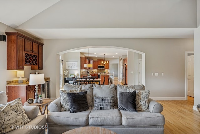 651 Clover Dr, Algonquin, IL 60102 - living area with arched walkways, light wood finished floors, wine cooler, baseboards, and recessed lighting