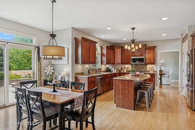 651 Clover Dr, Algonquin, IL 60102 - kitchen with appliances with stainless steel finishes, a sink, a chandelier, tasteful backsplash, and a kitchen island