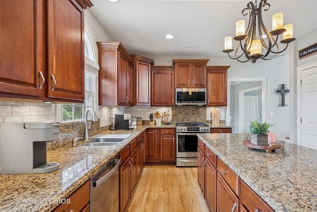 651 Clover Dr, Algonquin, IL 60102 - kitchen featuring stainless steel appliances, a sink, light wood-style flooring, light stone counters, and pendant lighting