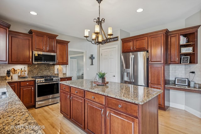 651 Clover Dr, Algonquin, IL 60102 - kitchen featuring appliances with stainless steel finishes, light wood-style floors, decorative backsplash, pendant lighting, and a chandelier