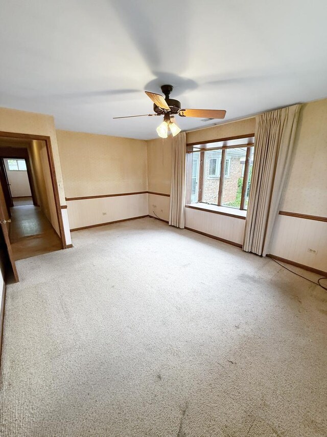942 W Villa Dr, Des Plaines, IL 60016 - carpeted empty room with healthy amount of natural light, a wainscoted wall, and ceiling fan