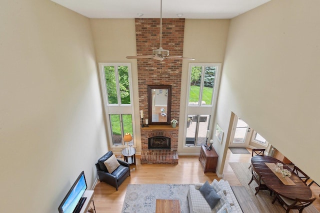 2156 Red Maple Ln, Aurora, IL 60502 - living room with wood finished floors, a fireplace, a ceiling fan, and a towering ceiling