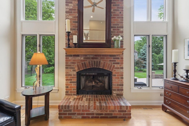 2156 Red Maple Ln, Aurora, IL 60502 - living area with light wood-type flooring, a brick fireplace, and baseboards