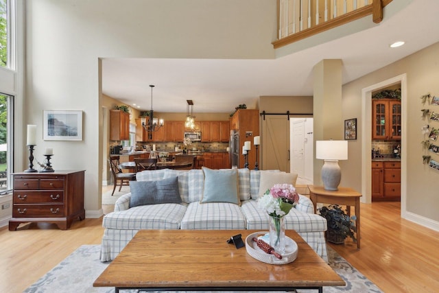 2156 Red Maple Ln, Aurora, IL 60502 - living area featuring a towering ceiling, a barn door, light wood-type flooring, recessed lighting, and a chandelier