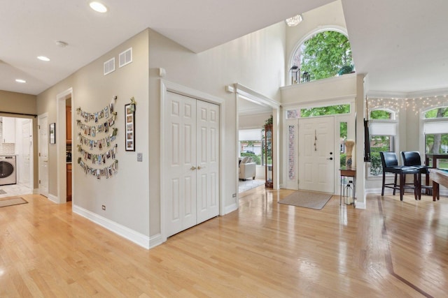 2156 Red Maple Ln, Aurora, IL 60502 - foyer entrance with washer / clothes dryer, plenty of natural light, light wood-style floors, and recessed lighting