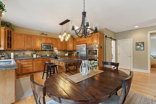 2156 Red Maple Ln, Aurora, IL 60502 - dining area with a barn door, a chandelier, light wood-type flooring, baseboards, and recessed lighting