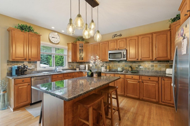 2156 Red Maple Ln, Aurora, IL 60502 - kitchen with appliances with stainless steel finishes, a kitchen bar, brown cabinetry, light wood-style floors, and recessed lighting