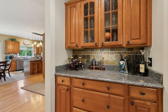 2156 Red Maple Ln, Aurora, IL 60502 - kitchen featuring dishwasher, light wood finished floors, brown cabinetry, backsplash, and glass insert cabinets