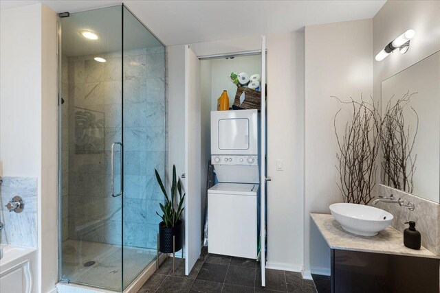 600 N Fairbanks Ct Unit 3306, Chicago, IL 60611 - full bathroom with stacked washer / drying machine, a shower stall, vanity, baseboards, and a bathtub