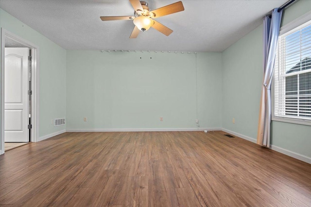3100 Shepard Rd, Normal, IL 61761 - spare room featuring wood finished floors, ceiling fan, baseboards, and a textured ceiling