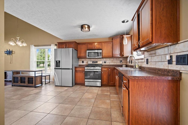 3100 Shepard Rd, Normal, IL 61761 - kitchen with stainless steel appliances, dark countertops, a sink, brown cabinetry, and a textured ceiling