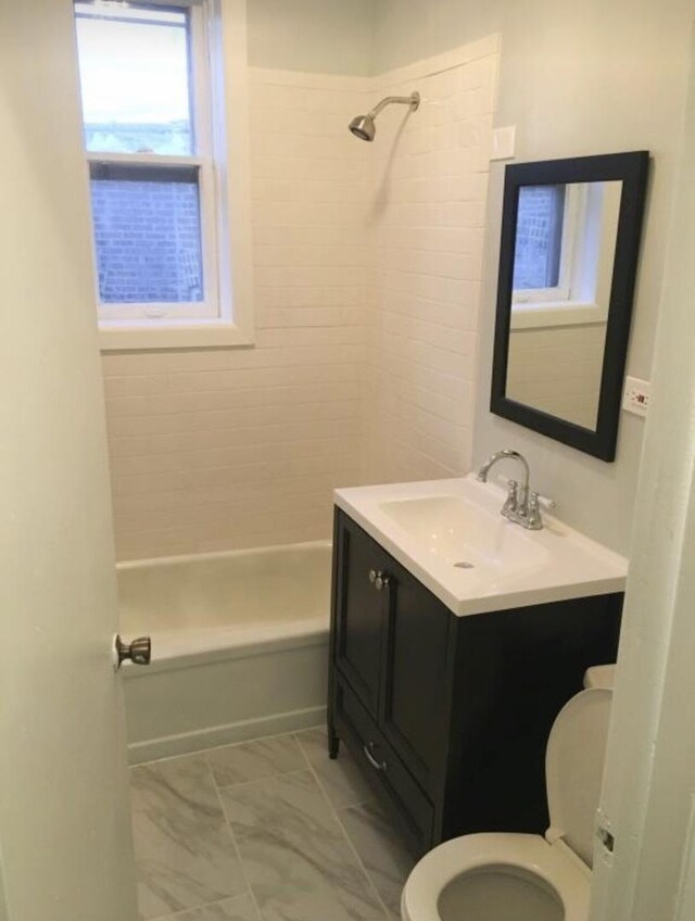 6838 S Clyde Ave, Chicago, IL 60649 - full bathroom with toilet, vanity, tub / shower combination, and marble look tiles