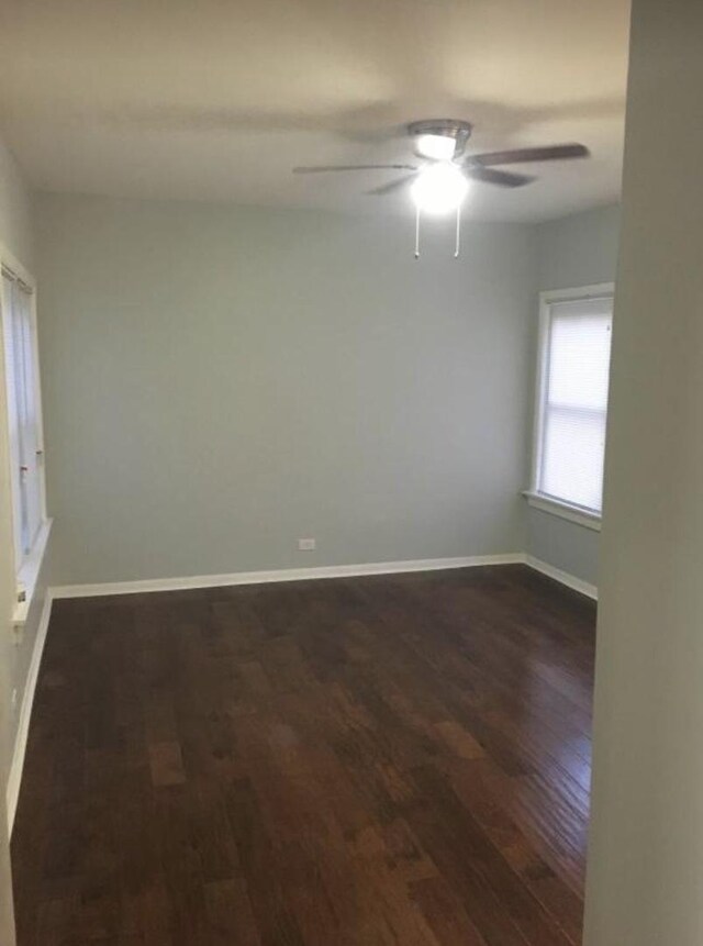 6838 S Clyde Ave, Chicago, IL 60649 - empty room featuring dark wood-style floors, ceiling fan, and baseboards