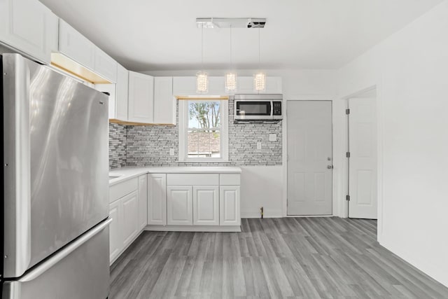 14856 Perry Ave, South Holland, IL 60473 - kitchen with appliances with stainless steel finishes, light wood finished floors, decorative backsplash, and white cabinets