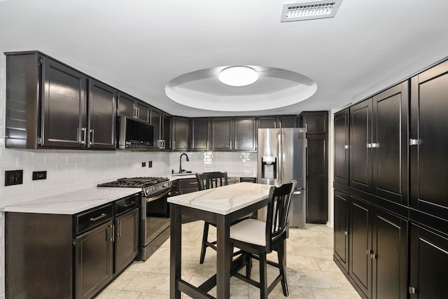 4739 W 105th St Unit 101, Oak Lawn, IL 60453 - kitchen with appliances with stainless steel finishes, a raised ceiling, a sink, and tasteful backsplash