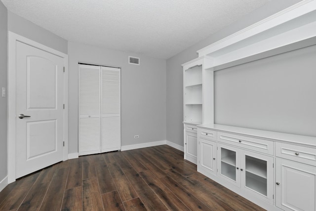 4739 W 105th St Unit 101, Oak Lawn, IL 60453 - unfurnished bedroom featuring dark wood-style floors, baseboards, a textured ceiling, and a closet