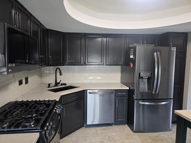 4739 W 105th Pl Unit 101, Oak Lawn, IL 60453 - kitchen with appliances with stainless steel finishes, a sink, light countertops, decorative backsplash, and dark cabinets