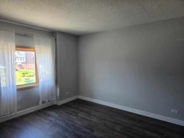 4739 W 105th Pl Unit 101, Oak Lawn, IL 60453 - empty room with dark wood-style flooring, a textured ceiling, and baseboards