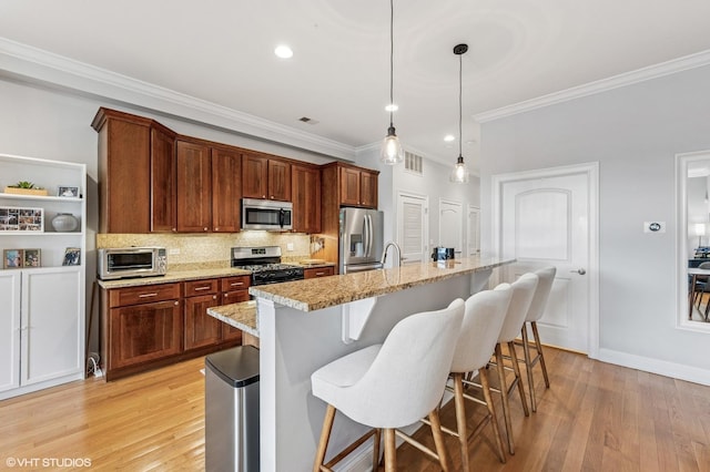 4141 N Kedzie Ave Unit 204, Chicago, IL 60618 - kitchen featuring stainless steel appliances, crown molding, light wood-style flooring, decorative backsplash, and a breakfast bar area