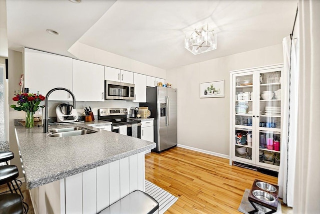 714 Shepard Ct, Gurnee, IL 60031 - kitchen with appliances with stainless steel finishes, a kitchen breakfast bar, a sink, baseboards, and white cabinetry