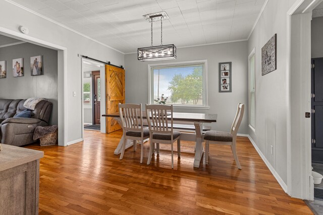 207 N E Ave, Ogden, IL 61859 - dining room with crown molding, a barn door, light wood-style floors, and baseboards