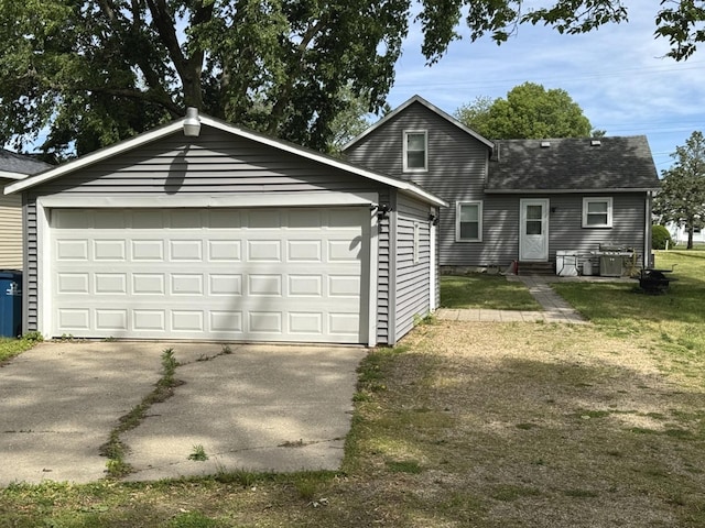 25 W Main St, Amboy, IL 61310 - view of front of house featuring a shingled roof, concrete driveway, an outbuilding, and an attached garage