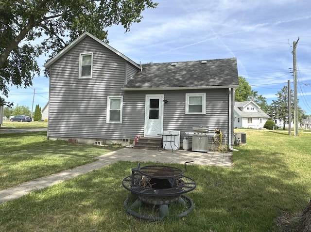 25 W Main St, Amboy, IL 61310 - back of house featuring a shingled roof, a yard, central AC unit, and a fire pit