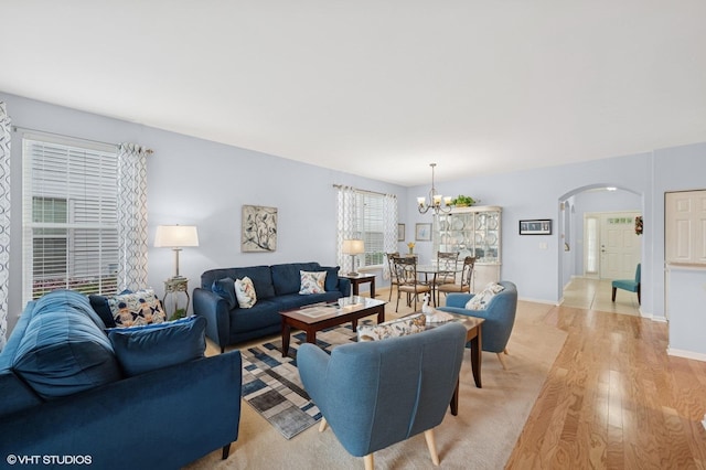 1736 Francis Dr, Pingree Grove, IL 60140 - living area with arched walkways, light wood finished floors, a chandelier, and baseboards