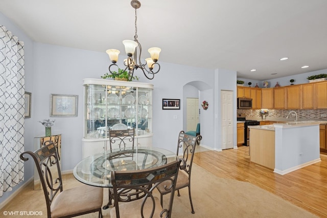 1736 Francis Dr, Pingree Grove, IL 60140 - dining space with arched walkways, a chandelier, light wood finished floors, baseboards, and recessed lighting
